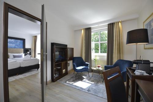 a hotel room with a bedroom with a bed and a tv at Hotel Caroline Mathilde in Celle