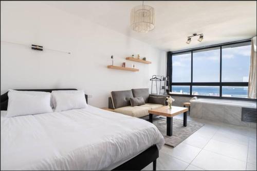 a bedroom with a large bed and a bath tub at eve's room in Haifa