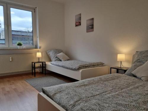 a bedroom with two beds and a window at Möblierte 3 Zimmer Apartment - Mit Smart TV, Wlan und kostenfreie Parkplätze in Schloß Holte-Stukenbrock