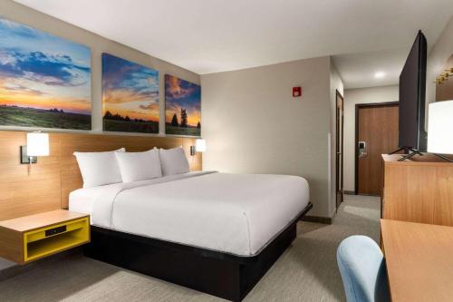 a hotel room with a bed and a flat screen tv at Days Inn by Wyndham Washington Court House in Washington Court House