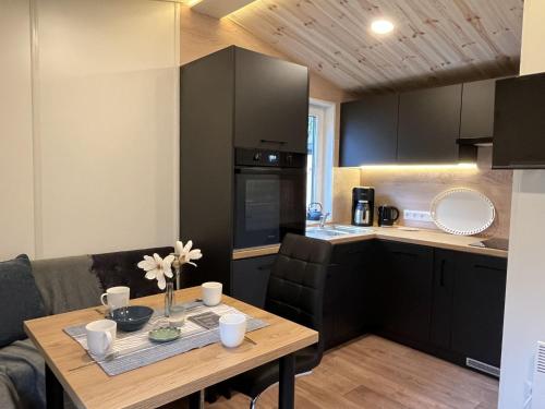 a kitchen with a wooden table and a kitchen with black cabinets at Holiday Home Soul & Forest by Interhome in Wemding