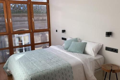 Apartamento en Casco Vello Vigo في فيغو: غرفة نوم بسرير ونافذة كبيرة