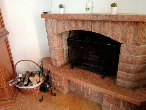 a brick fireplace with a basket of logs at Terrazza Rinaldi - centro - wifi - Panoramico in Fanano