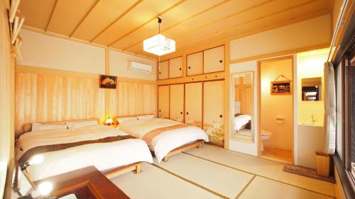 2 camas en un dormitorio con paredes de madera en 2 separate houses※Garden/Hakone 3min walk from Sta en Hakone