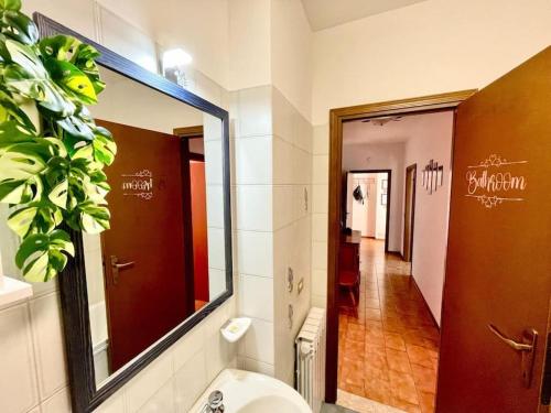 a bathroom with a sink and a mirror and a hallway at Terrazza Rinaldi - centro - wifi - Panoramico in Fanano