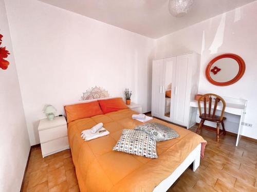 a bedroom with a large orange bed and a desk at Terrazza Rinaldi - centro - wifi - Panoramico in Fanano