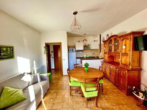 a living room with a table and a kitchen at Terrazza Rinaldi - centro - wifi - Panoramico in Fanano