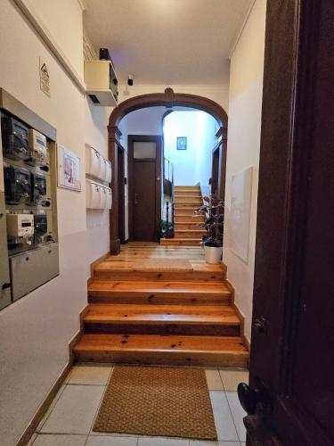 a hallway with wooden stairs and an archway at Vila Queirós, 6 in Lisbon