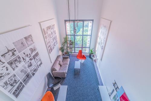 uma sala de estar com um sofá e uma cadeira vermelha em Residence Montempo Lyon Cite Internationale em Lyon