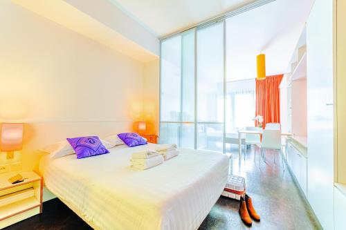 里昂Residence Montempo Lyon Cite Internationale的卧室里有一张大床，配有紫色枕头