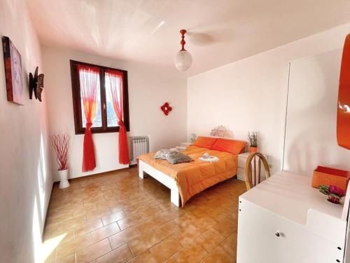 a bedroom with a bed with orange sheets in it at Terrazza Rinaldi - centro - wifi - Panoramico in Fanano