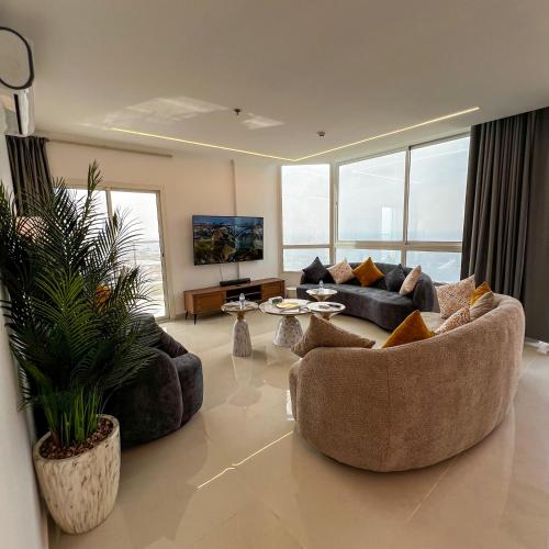 a living room with two couches and a tv at Sky-high Villa فيلا عنان السماء in Jeddah