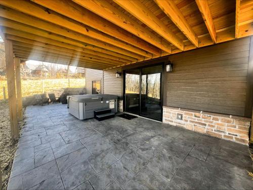 an outdoor patio with a fireplace and a wooden ceiling at Heavenly Summit in McHenry