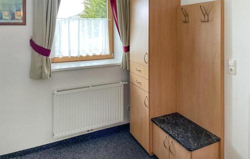 een kamer met een houten kast en een raam bij Amazing Apartment In Navis With Kitchen in Navis