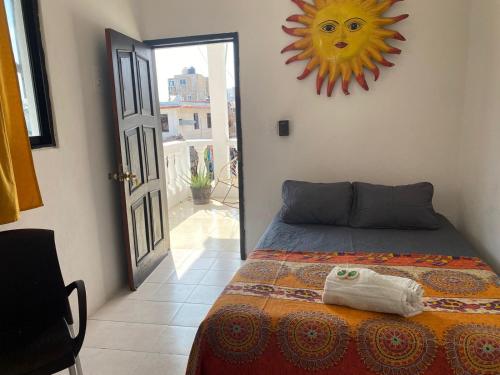 a bedroom with a bed with a sun on the wall at Posada DORA in Isla Mujeres