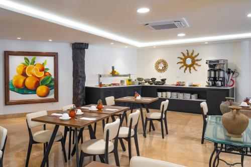 a restaurant with tables and chairs and a kitchen at Eurostars Hacienda Vista Real in Playa del Carmen