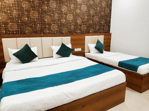 two beds in a hotel room with blue and white at HOTEL JVS PALACE in Gorakhpur