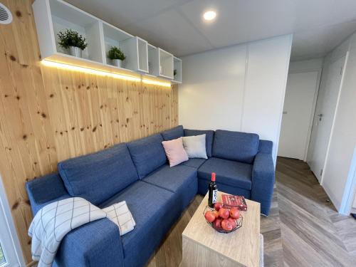 a living room with a blue couch and a table at Holiday Home Tiny Haus Altmühlblick II by Interhome in Riedenburg