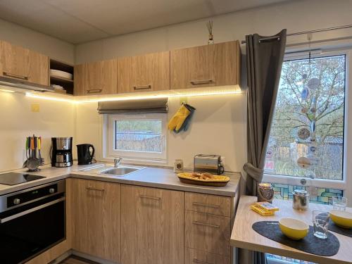 a kitchen with wooden cabinets and a sink and a window at Holiday Home Karin by Interhome in Wemding