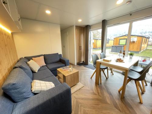 a living room with a blue couch and a table at Holiday Home Tiny Haus Rotkehlchen by Interhome in Riedenburg