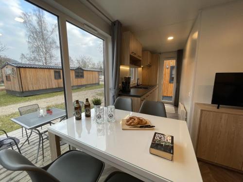 eine Küche und ein Esszimmer mit einem Tisch und einem Fenster in der Unterkunft Holiday Home Tiny Haus Rotkehlchen by Interhome in Riedenburg