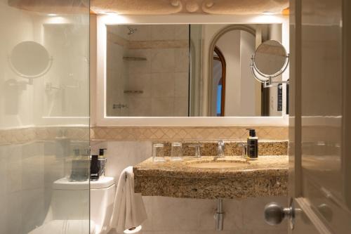 y baño con lavabo, espejo y aseo. en Eurostars Hacienda Vista Real, en Playa del Carmen
