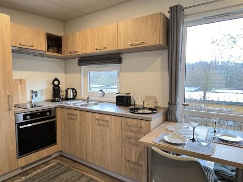 a kitchen with a sink and a counter with a table at Holiday Home Tiny Haus mit schönem Seeblick by Interhome in Wemding