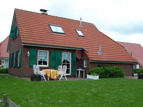 una casa con tavolo e sedie nel cortile di Ferienwohnungen Höhn ad Altfunnixsiel