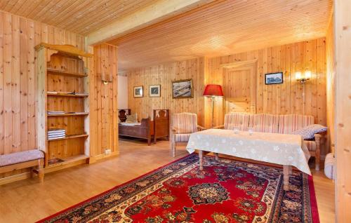 sala de estar con paredes de madera, mesa y sillas en Awesome Apartment In Haltdalen With Kitchen, en Haltdalen