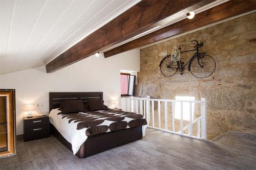 a bedroom with a bed and a bike hanging on a wall at Casa Nova in Carnota
