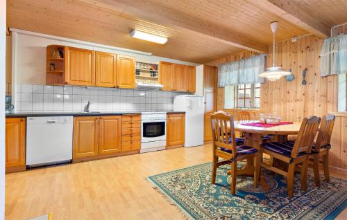 una cocina con armarios de madera, mesa y sillas en Awesome Apartment In Haltdalen With Kitchen, en Haltdalen