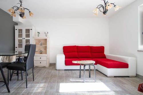 a living room with a red couch and a table at Casa Nova in Carnota