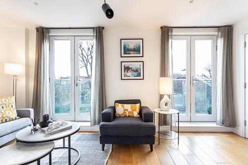 a living room with a couch and a chair at Tranquil Belsize Park Haven with Stunning Views in London