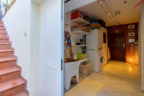 a kitchen with a sink and a refrigerator at sunny courtyard in Piombino