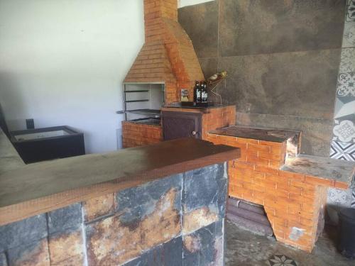 uma cozinha com um balcão de tijolos e um forno em Chalé Canastra Zoo em Capitólio