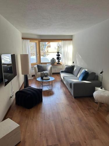 uma sala de estar com um sofá e uma mesa em Wonderful cosy apartment in St. Moritz em St. Moritz