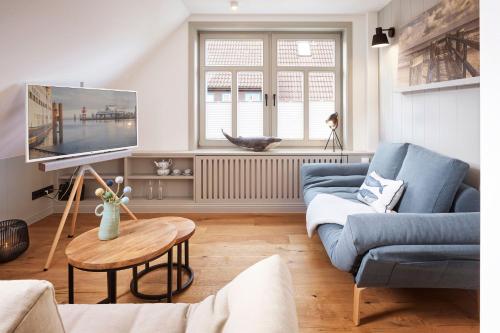 een woonkamer met een blauwe bank en een tv bij Studio 6 in Wyk auf Föhr