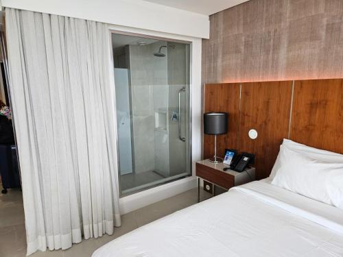 Schlafzimmer mit einem Bett und einer Glasdusche in der Unterkunft Hotel Nacional in Rio de Janeiro