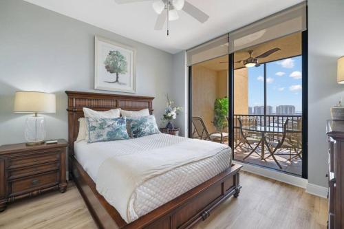 ein Schlafzimmer mit einem Bett und einem Balkon in der Unterkunft Luxury Condo at Cape Harbour Marina, Water Views! in Cape Coral