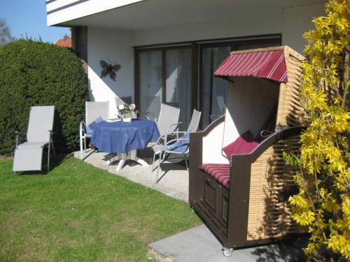 a patio with a table and chairs and a table and chairs at Ferienwohnung Goldan Möwenweg in Carolinensiel