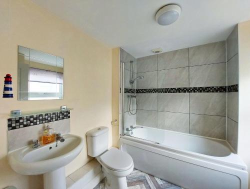 a bathroom with a sink and a toilet and a shower at Hafan Y Traeth Beach Front Apartment in Barmouth in Barmouth