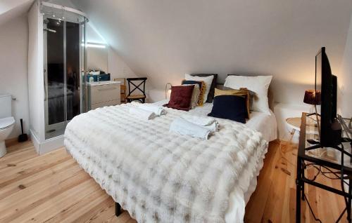 une chambre avec un grand lit blanc avec des oreillers dans l'établissement Nice Home In Ploubazlanec With Kitchen, à Ploubazlanec