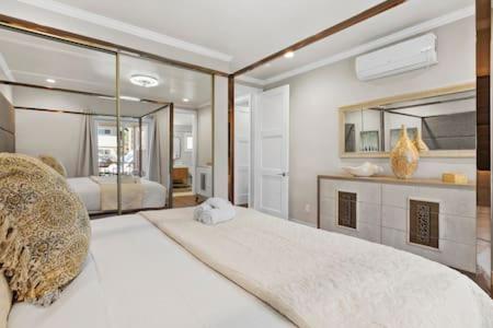 een slaapkamer met een groot wit bed en een spiegel bij Champagne Taste Luxury Home in Hillcrest in San Diego