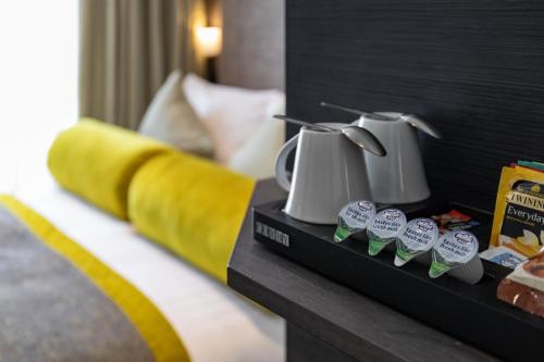 a hotel room with a table with two pitchers and cupcakes at Mornington Hotel London Victoria in London