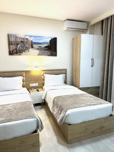 2 Betten in einem Hotelzimmer mit einem Schlafzimmer in der Unterkunft Navarino Luxe Suites with Sea View in Peraia