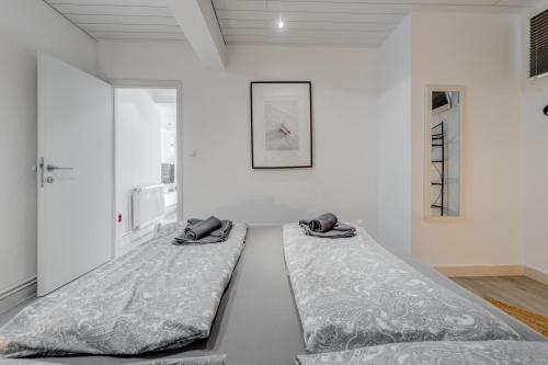 2 camas num quarto com paredes brancas em Luxury apartment with pool large patio & sea view em Omiš