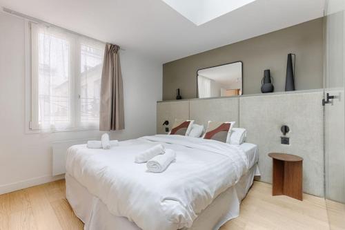 une chambre avec un grand lit blanc avec un miroir dans l'établissement MyKeypers - Luxury Design Flat 2BR/6P - Rue de Charonne !, à Paris