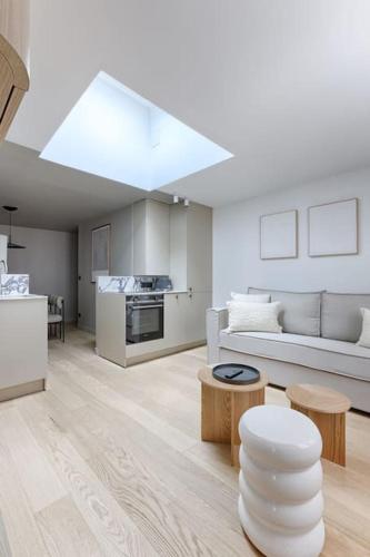 un salon blanc avec un canapé et une table dans l'établissement MyKeypers - Luxury Design Flat 2BR/6P - Rue de Charonne !, à Paris
