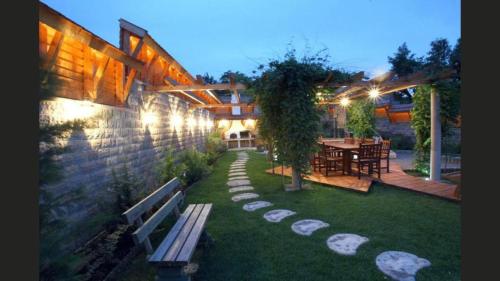 a garden with a bench and a table and a building at Kulacs Csarda Panzio in Eger