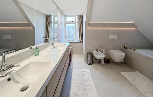 a bathroom with a sink and a tub and a toilet at Cozy Home In Noordwijk Aan Zee With Kitchen in Amsterdam